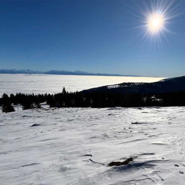 Blick von einem Berg in der Sonne auf das Nebelmeer